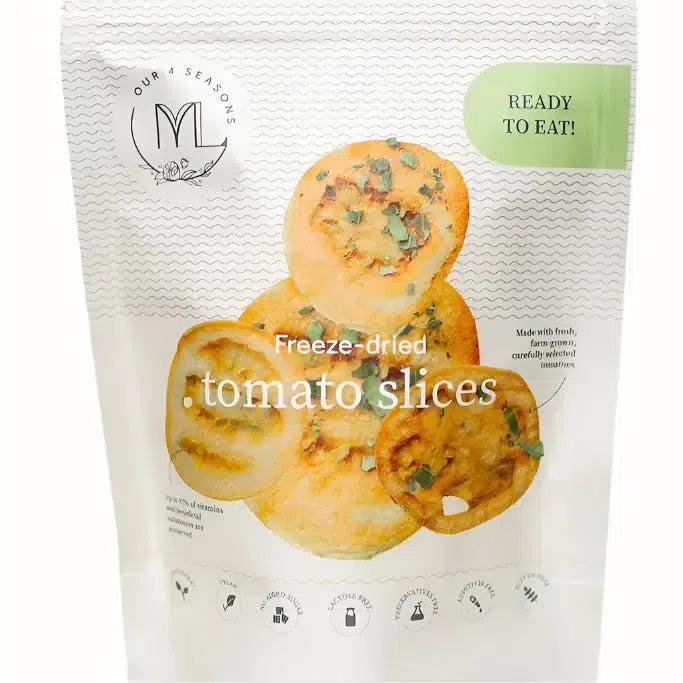 A packet of freeze-dried tomato slices, featuring a front label with clear imagery of the tomato slices. The product is labeled "Ready to Eat!" and made from fresh, farm-grown, carefully selected tomatoes. It highlights high vitamin content with sustainability and quality icons at the bottom of the packaging.