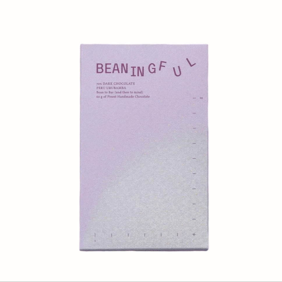 A light purple chocolate bar wrapper with the "Beaningful" logo. The wrapper displays the product's details, including "70% Dark Chocolate" and "Peru Urubamba," with a "Bean to Bar" label and measurements along the side.