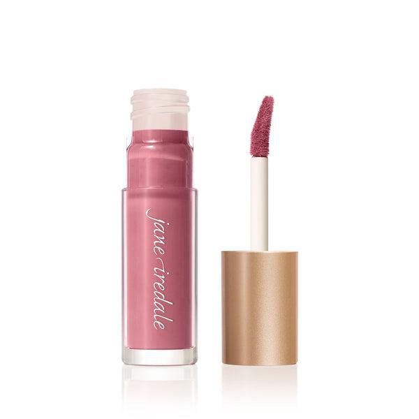 A tube of Jane Iredale Lip Gloss in a soft pink shade with a glossy finish, accompanied by a precise, doe-foot applicator for easy application. This lip gloss provides a smooth texture and a natural, hydrated look, perfect for everyday wear. The sleek, gold-colored packaging adds a touch of elegance to your beauty routine.