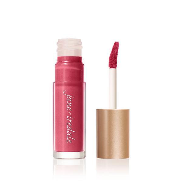 A tube of Jane Iredale Lip Gloss in a soft pink shade with a glossy finish, accompanied by a precise, doe-foot applicator for easy application. This lip gloss provides a smooth texture and a natural, hydrated look, perfect for everyday wear. The sleek, gold-colored packaging adds a touch of elegance to your beauty routine.