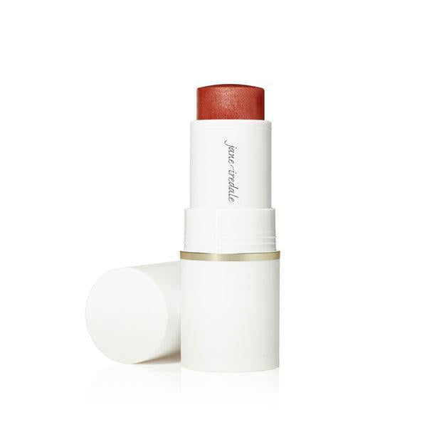 A stick of Jane Iredale Glow Time™ Pieštukiniai skaistalai. The blush is housed in a sleek white tube with a gold accent at the base. The product offers a rich, warm hue, ideal for creating a glowing, radiant flush on the cheeks.