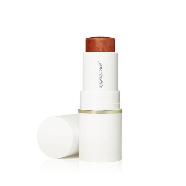 A stick of Jane Iredale Glow Time™ Pieštukiniai skaistalai. The blush is housed in a sleek white tube with a gold accent at the base. The product offers a rich, warm hue, ideal for creating a glowing, radiant flush on the cheeks.