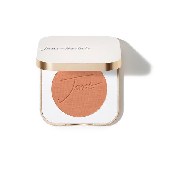Jane Iredale Blush
A compact case of Jane Iredale blush featuring a soft peachy-pink powder with the brand's name embossed on the surface. The compact is square-shaped with a gold trim and contains a generous amount of product.
