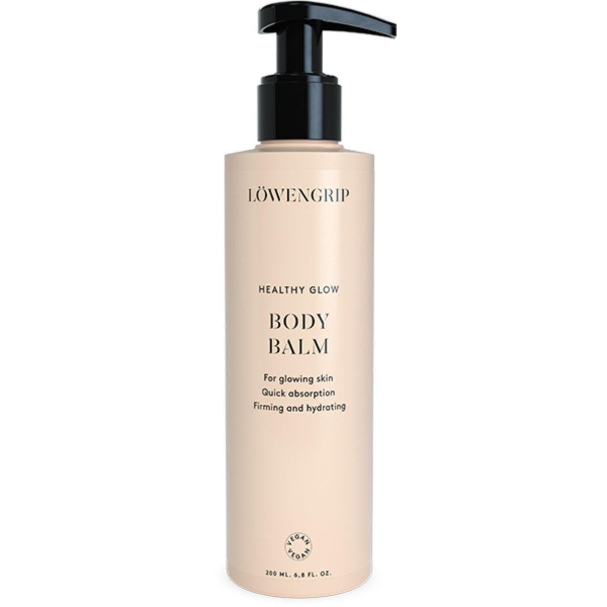A bottle of Löwengrip Healthy Glow Body Balm with a pump dispenser, labeled as a firming and hydrating balm designed for glowing skin. It promises quick absorption and is vegan-certified.