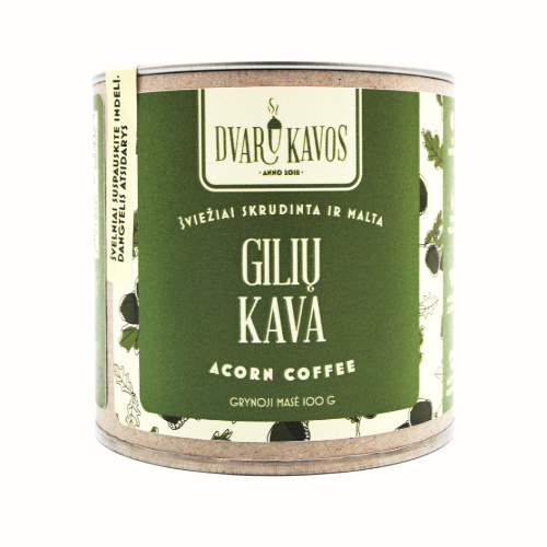 A can of Dvaru Kavos acorn coffee with the label in green, featuring the Lithuanian text "Gilių Kava" and "Acorn Coffee," along with illustrations of acorns and leaves. The product is labeled as freshly roasted and ground, with a net weight of 100g.