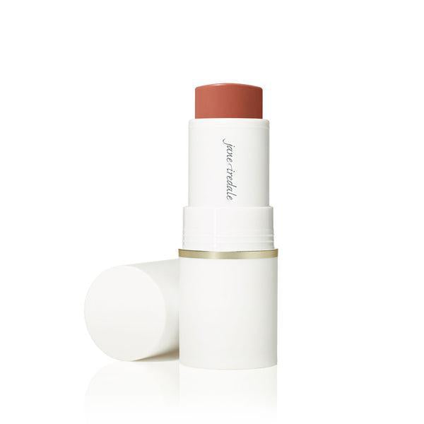 A stick of Jane Iredale Glow Time™ Pieštukiniai skaistalai. The blush is housed in a sleek white tube with a gold accent at the base. The product offers a rich, warm hue, ideal for creating a glowing, radiant flush on the cheeks.