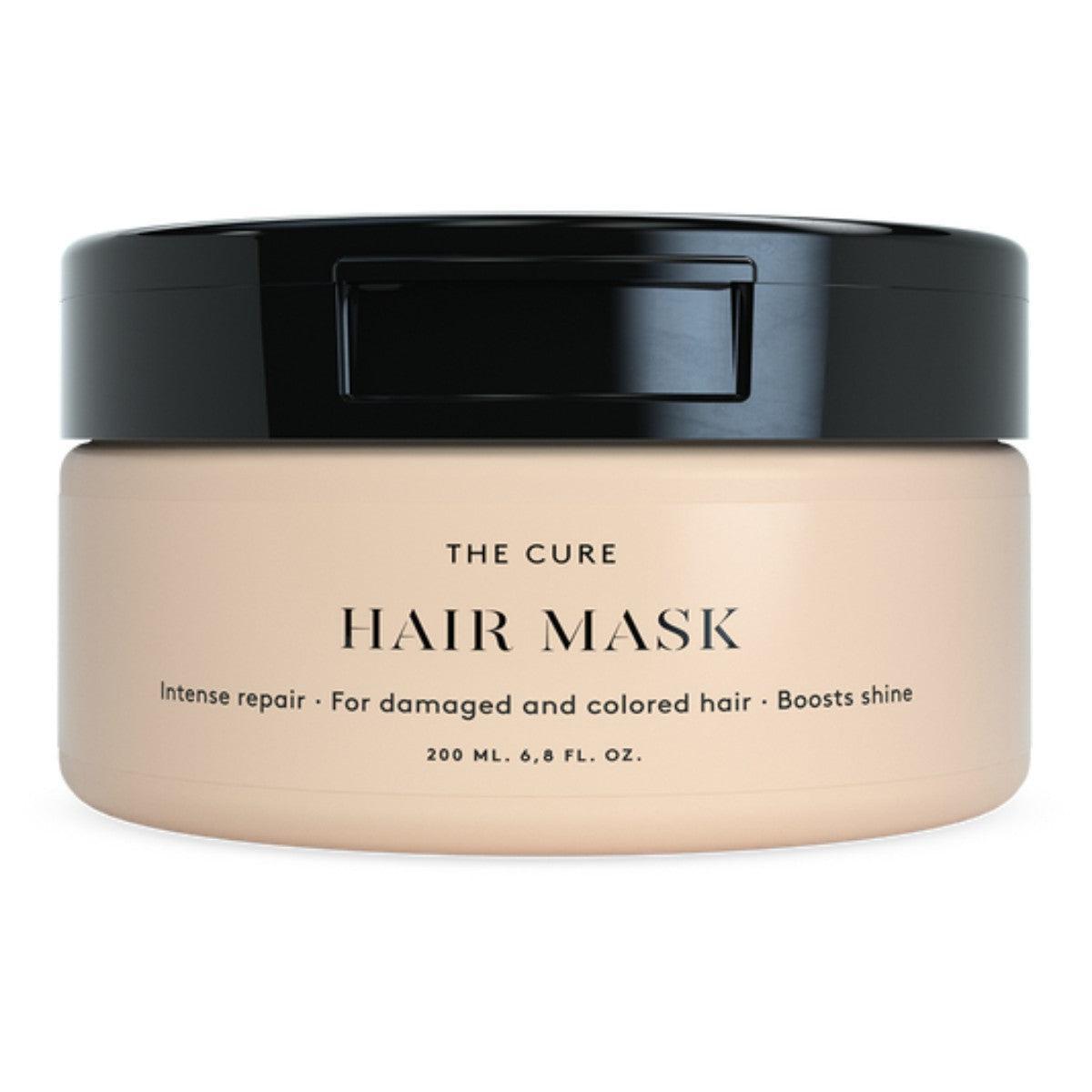 Löwengrip The Cure Hair Mask  
A tub of Löwengrip The Cure Hair Mask, designed for intense repair of damaged and colored hair. The product is labeled for boosting shine, and it is packaged in a soft beige container with a black lid. The label highlights the mask’s ability to provide intense repair and is suitable for both damaged and colored hair. The tub contains 200 mL (6.8 fl. oz.).