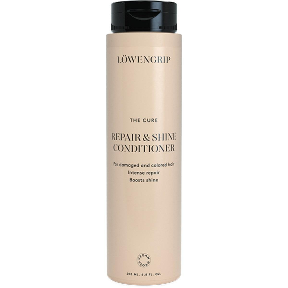 The Cure Repair & Shine Conditioner  
A bottle of The Cure Repair & Shine Conditioner by Löwengrip, designed for damaged and colored hair. It provides intense repair and boosts shine, with the label clearly indicating it is vegan. The product comes in a 200ml bottle with a sleek, neutral beige design and black lid, emphasizing its nourishing and color-protecting properties.