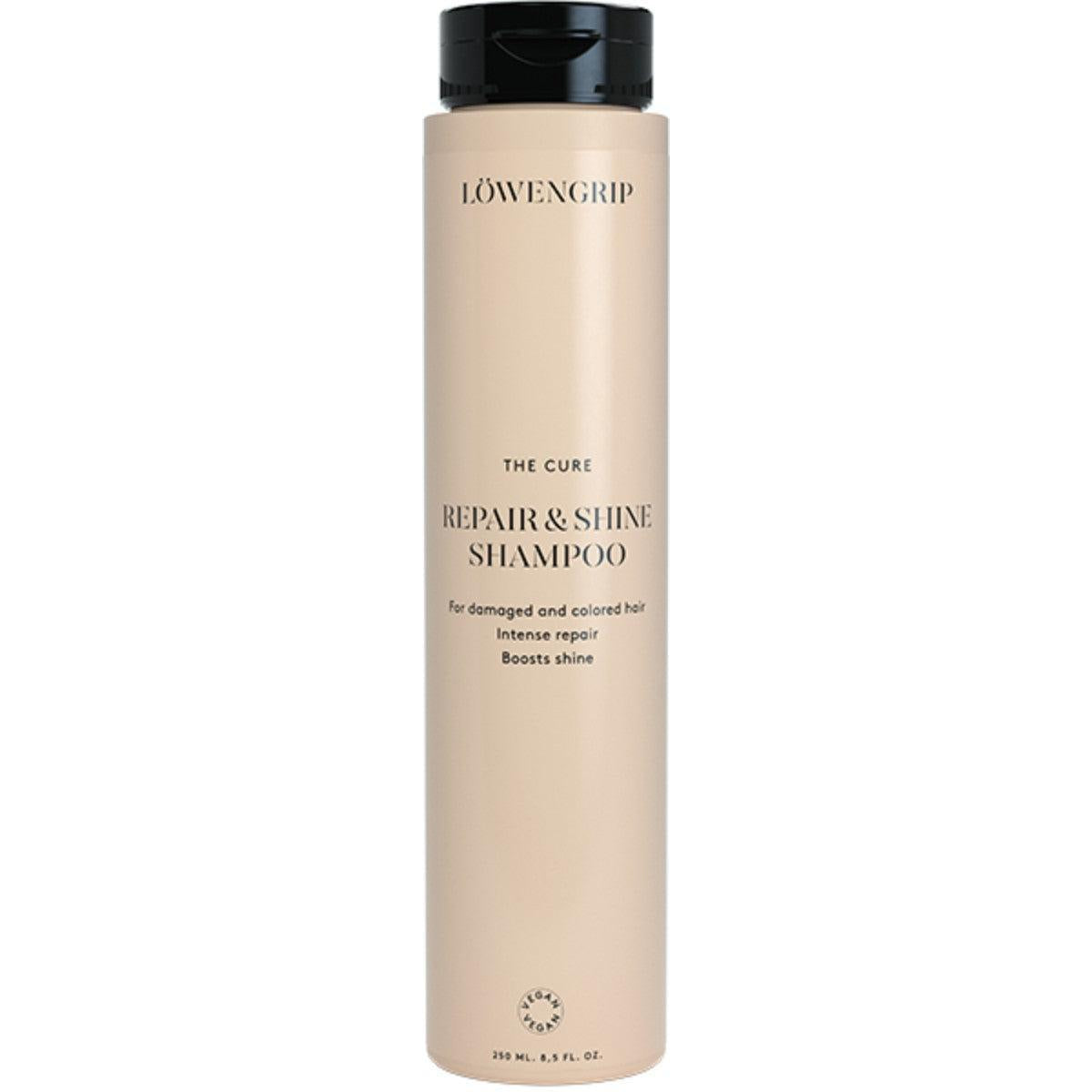 The Cure Repair & Shine Shampoo  
A bottle of The Cure Repair & Shine Shampoo by Löwengrip, designed for damaged and colored hair. It offers intense repair, boosts shine, and is vegan. The product comes in a 250ml bottle with a soft beige design and black cap, ideal for maintaining healthy, vibrant hair.
