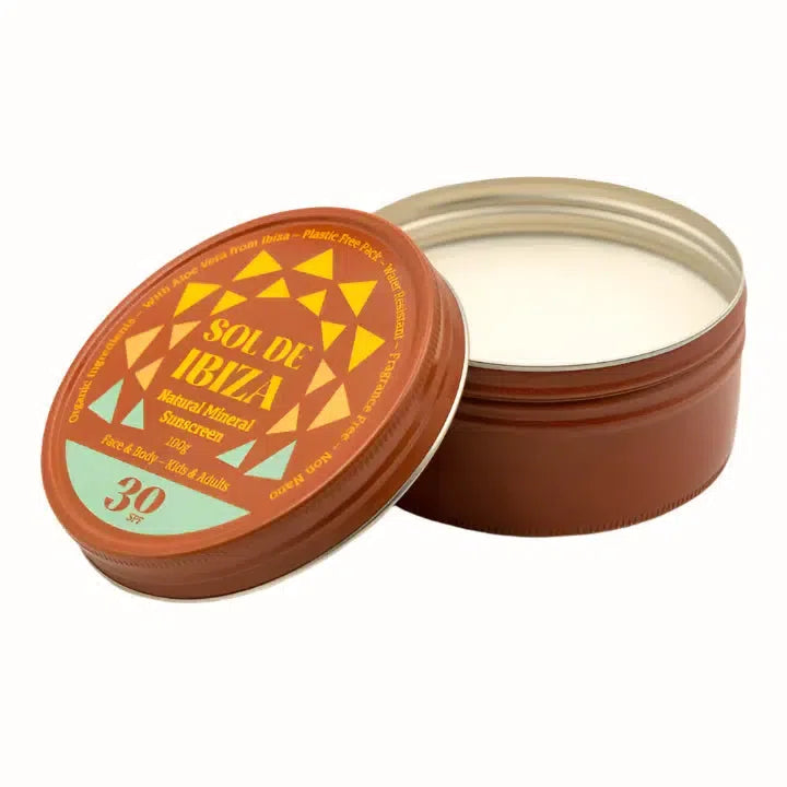 
A tin of Sol de Ibiza natural mineral sunscreen with SPF 30, featuring a vibrant orange and yellow label adorned with geometric shapes. The product is designed for both face and body use, suitable for kids and adults. It is formulated with organic ingredients, including aloe vera from Ibiza, and comes in a plastic-free, water-resistant packaging. The sunscreen is fragrance-free and is packaged in a 100g tin.
